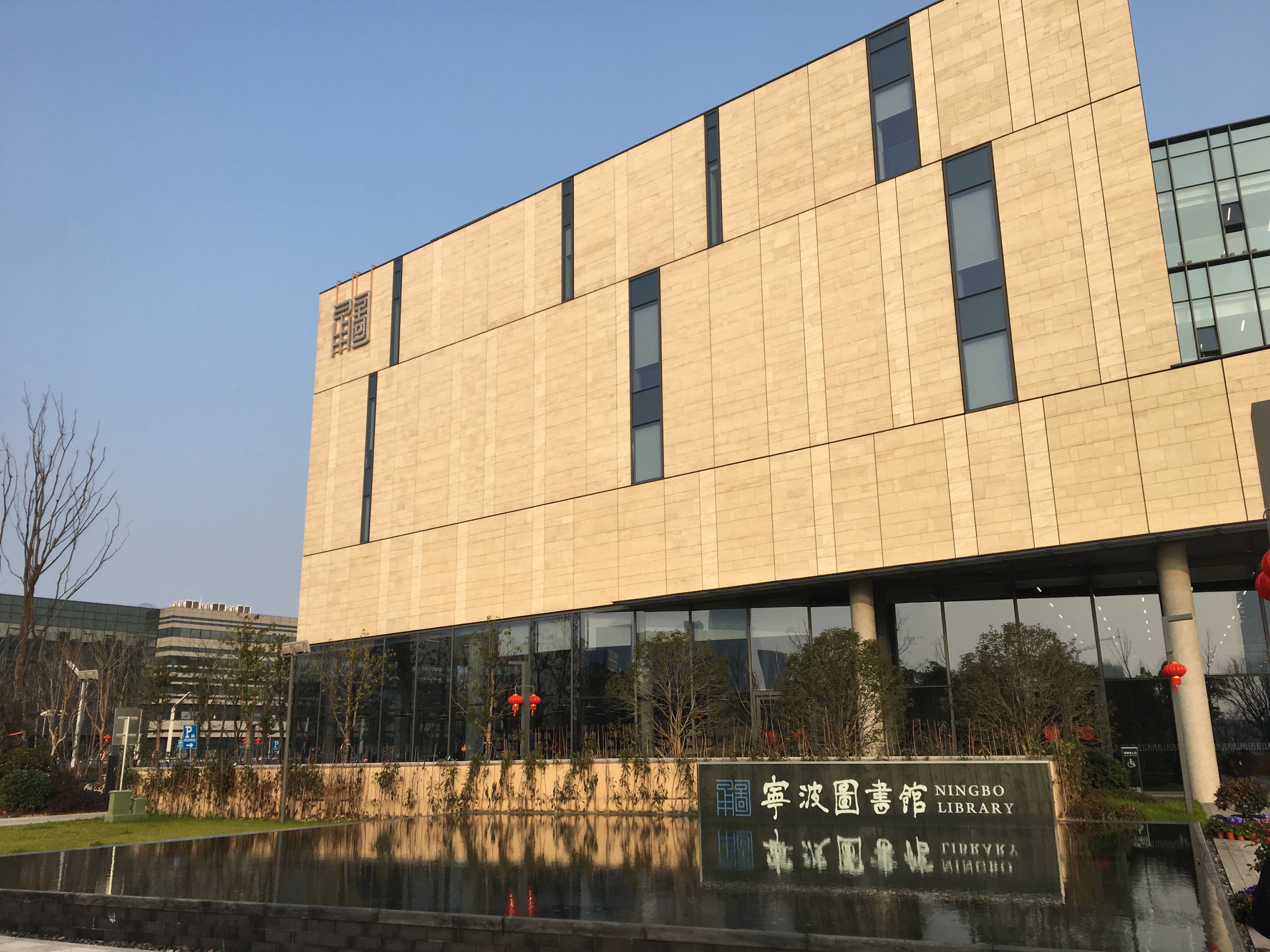 资料图：显示宁波图书馆建筑外观及正门前的水池与标牌。